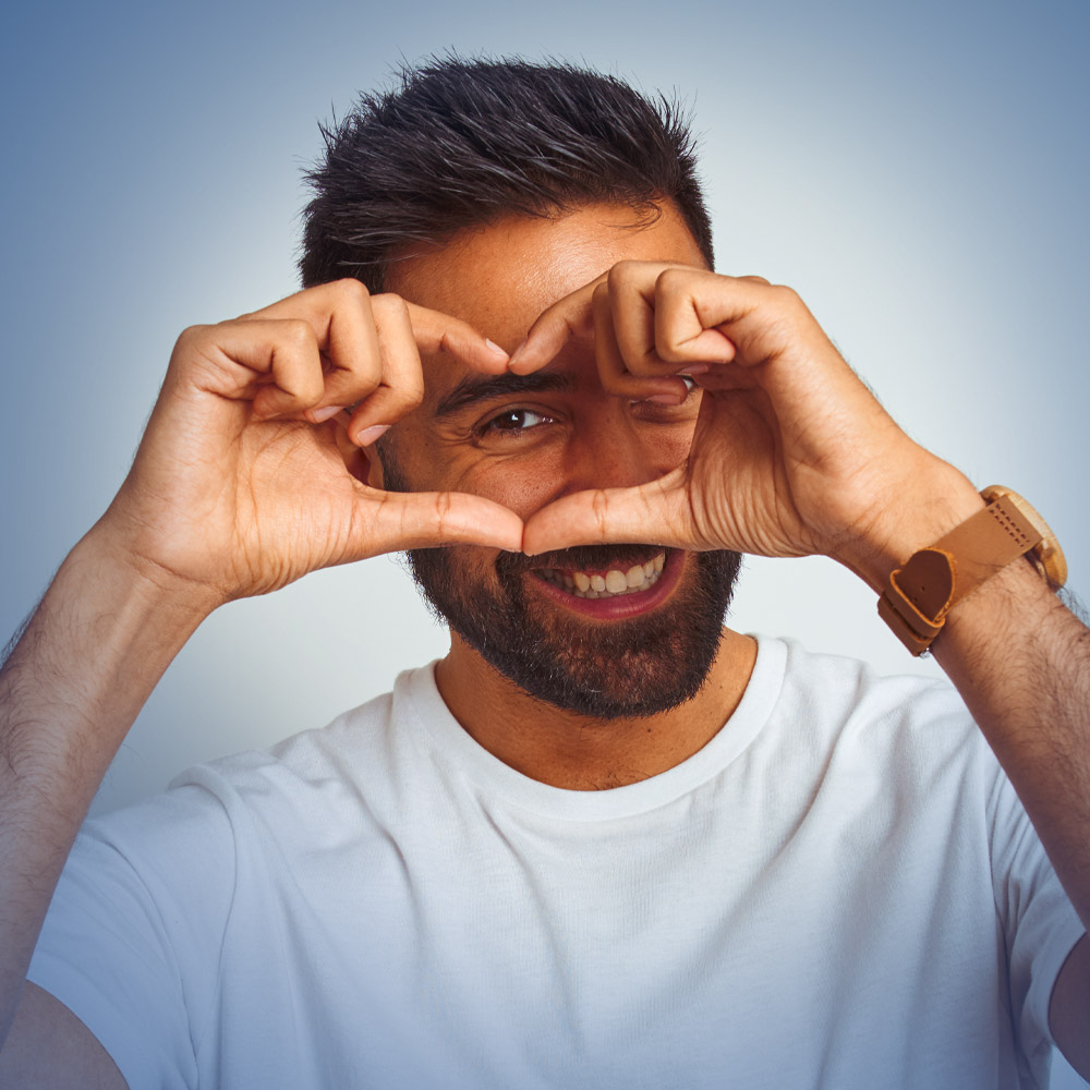 Close-up of a doctor's hands holding a detailed anatomical model of a human eye with a removable clear lens.